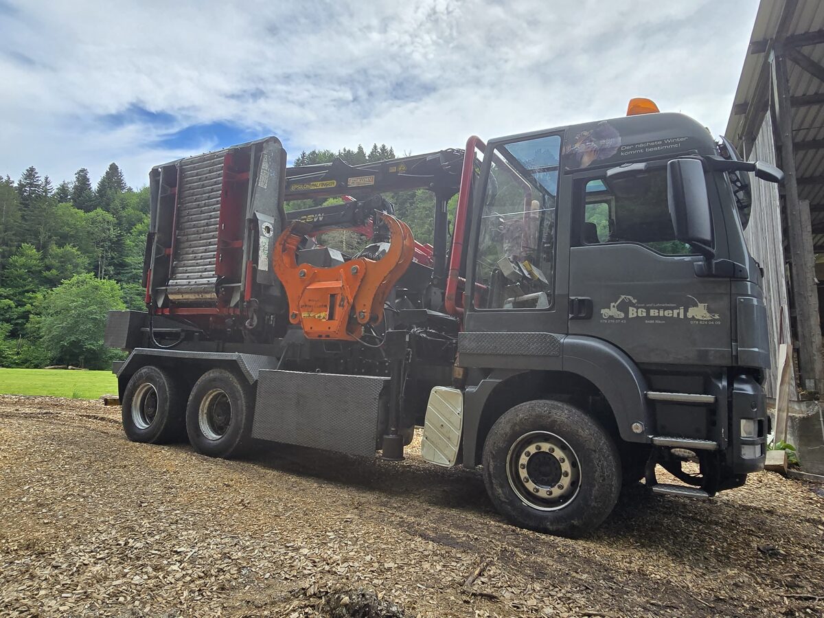 Cap tractor MAN cu tocătorul mobil pliat, pe o platformă acoperită cu tocătură